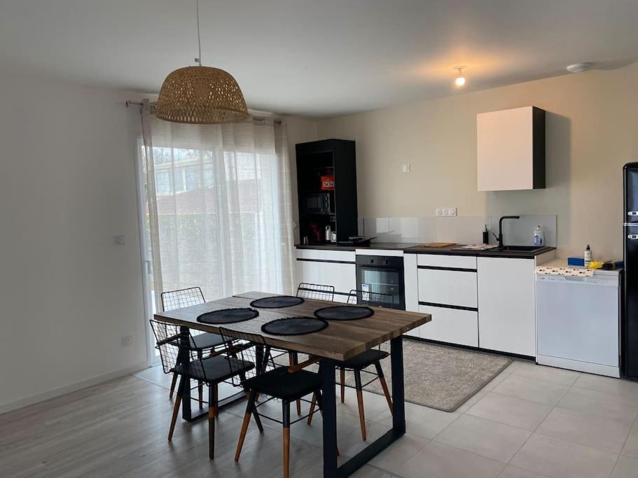 a kitchen with a table and chairs in a room at Villa by Nesma in Châtellerault