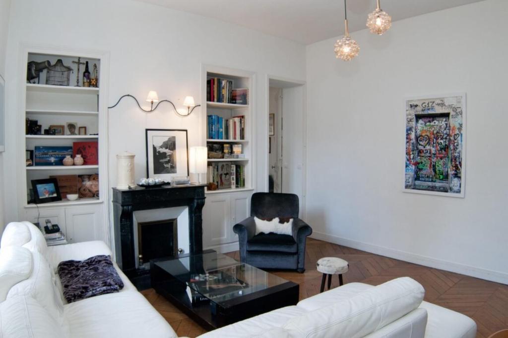 un salon avec un canapé blanc et une cheminée dans l'établissement Dream Catcher 3Bdr Paris apartment, à Paris