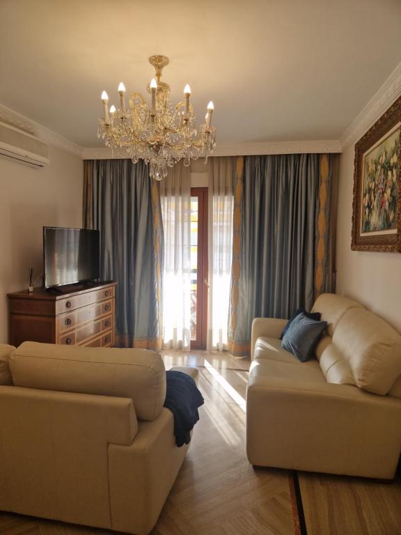 a living room with two couches and a chandelier at Apartamento Centro Marbella in Marbella