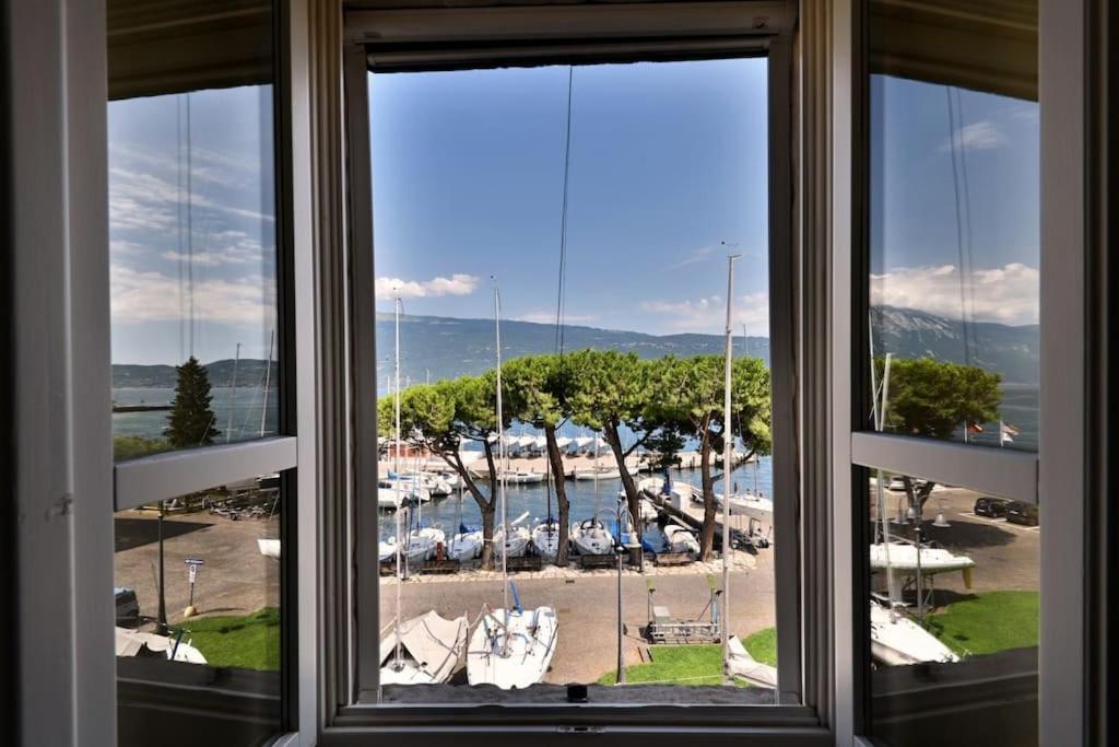 uma janela com vista para uma marina com barcos em Appartamento Al Porto Vecchio - Rebomaholidays em Gargnano