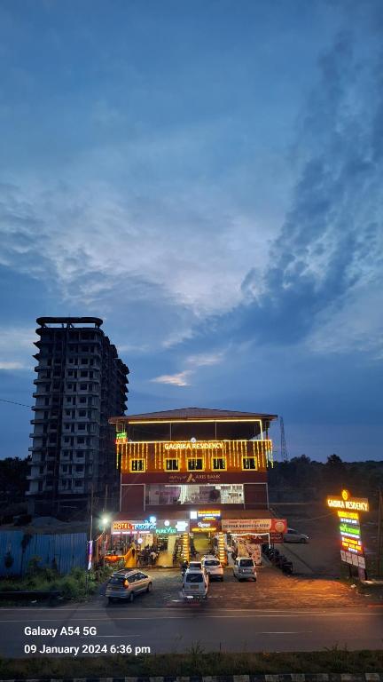 ein Parkplatz mit Autos vor einem Gebäude in der Unterkunft Gaurika Residency Boarding & Lodging - Padubidri in Padubidri