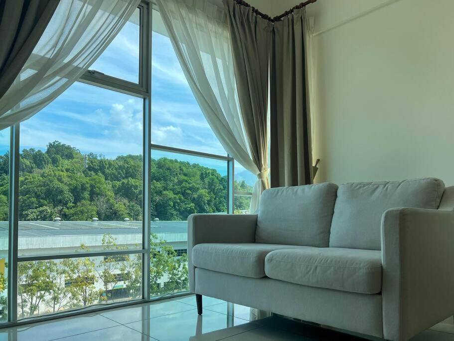 - un salon avec un canapé et une grande fenêtre dans l'établissement Comfy 2 Bedder Retreat Homestay near Taiping Lake Garden with Netflix, à Taiping