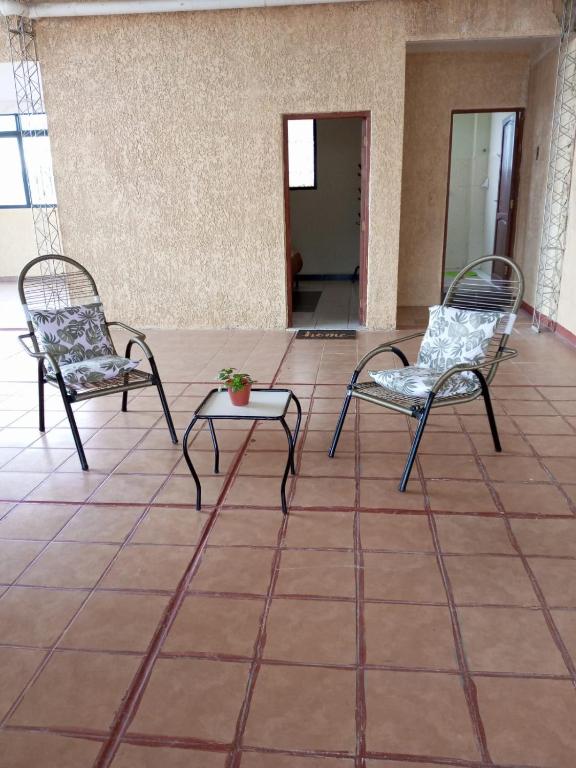 2 sillas y una mesa en el suelo de baldosa en hospedaje, independiente aranjuez, en Tarija