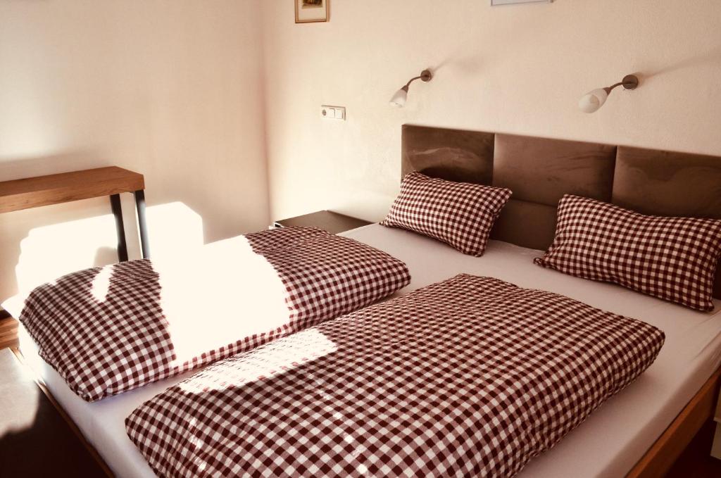 ゲルロスにあるHollys Appartementのベッドルーム1室(ベッド2台、チェック入り枕付)