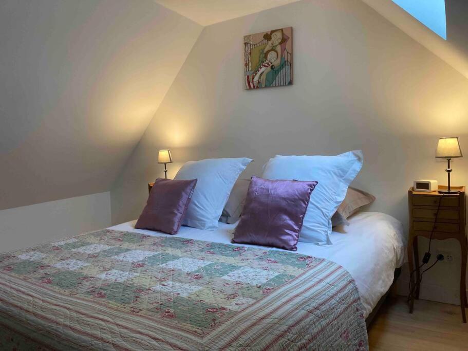 - une chambre avec un lit et des oreillers violets dans l'établissement Le Loft - Chenonceaux - Zoo de Beauval - 3*, à Bléré