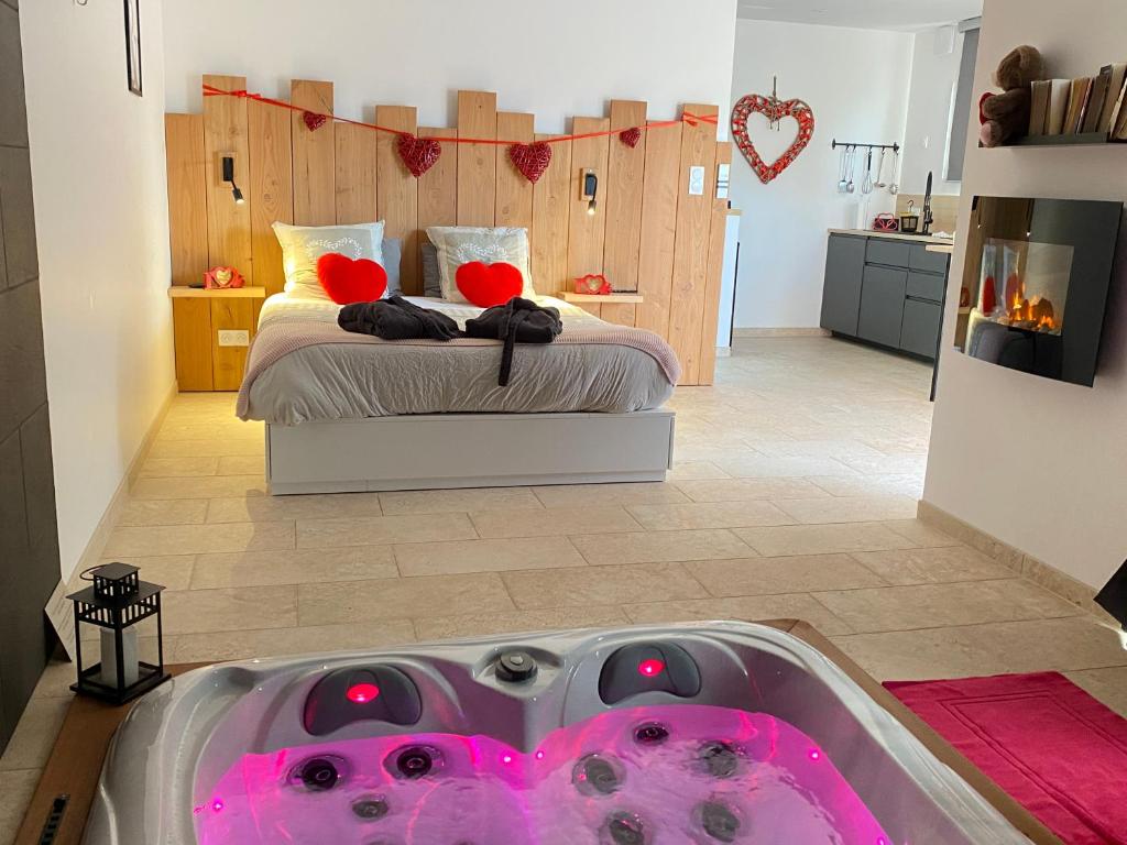 a bathroom with a tub in the middle of a bedroom at LOVE AND BULLES in Le Fleix