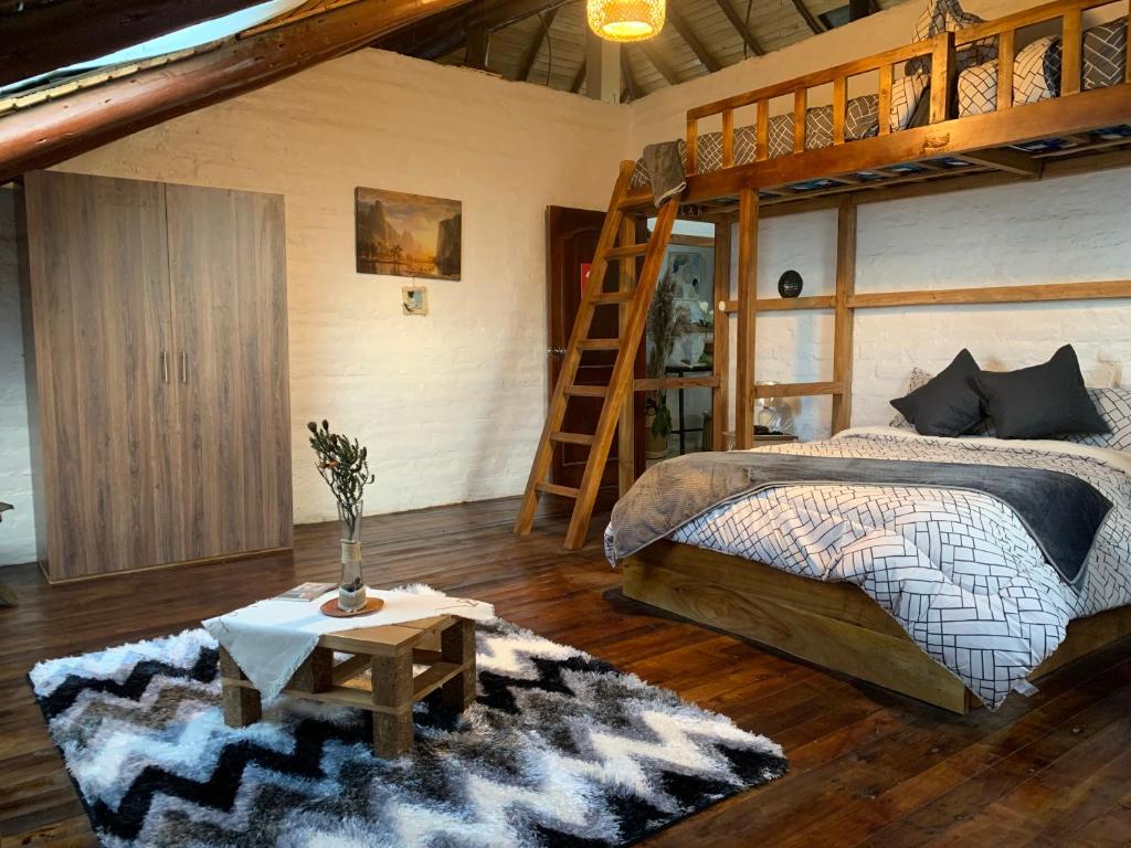 een slaapkamer met een stapelbed en een ladder bij Chimborazo Rey lodge hotel in Guaranda