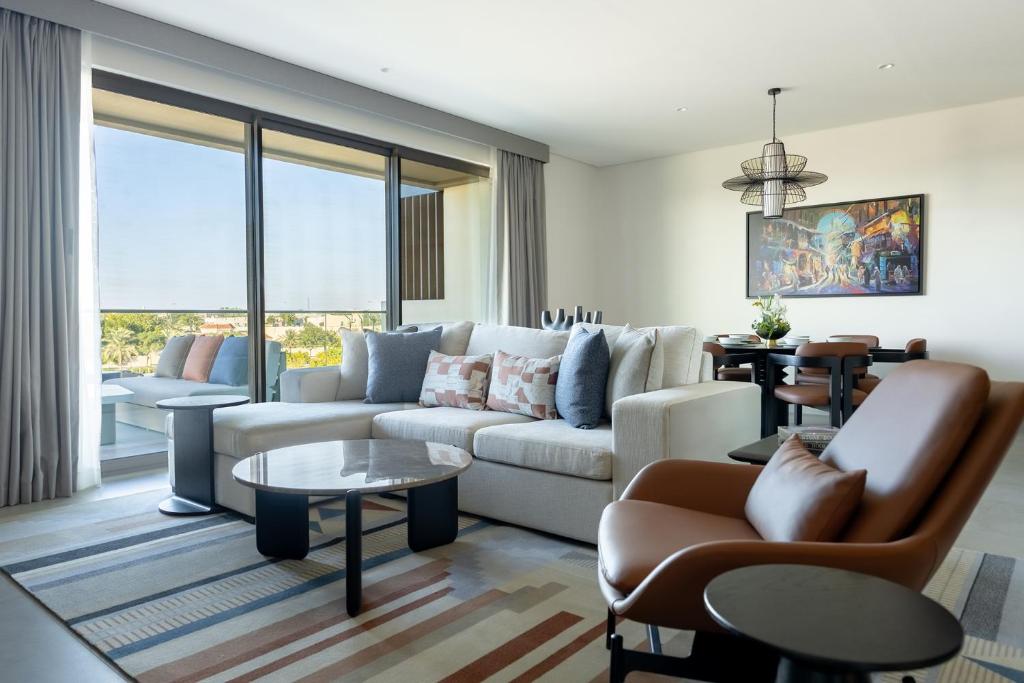 Fraser Suites Al Liwan في المنامة: غرفة معيشة مع أريكة وطاولة