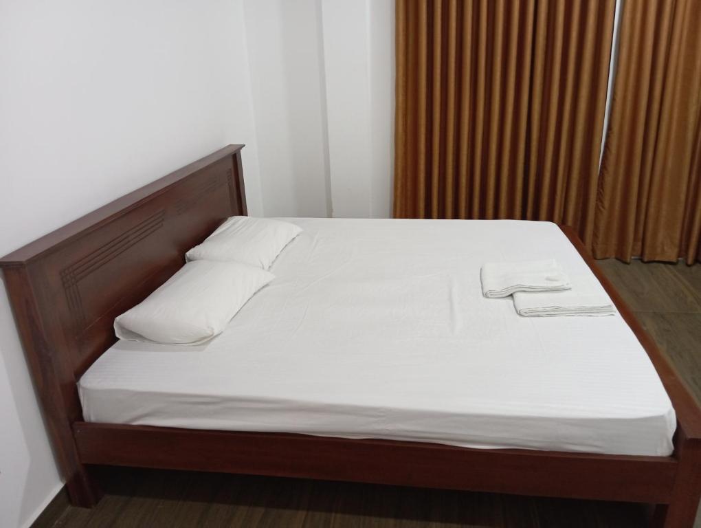- un lit avec des draps et des oreillers blancs dans l'établissement ROCK VIEW inn, à Padukka