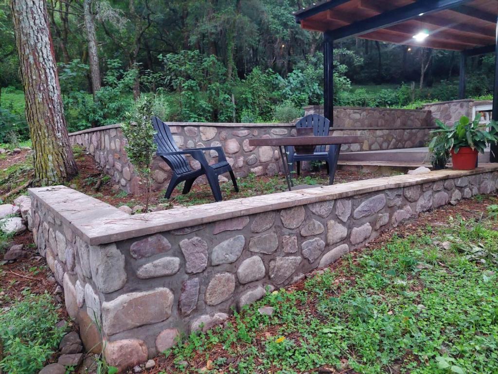 uma parede de pedra com um banco e uma mesa em Casas de Campo El Rincón em San Antonio