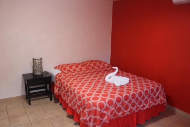 a bedroom with a bed with a white swan on it at Uverito Sand Dollar B&B in Las Tablas