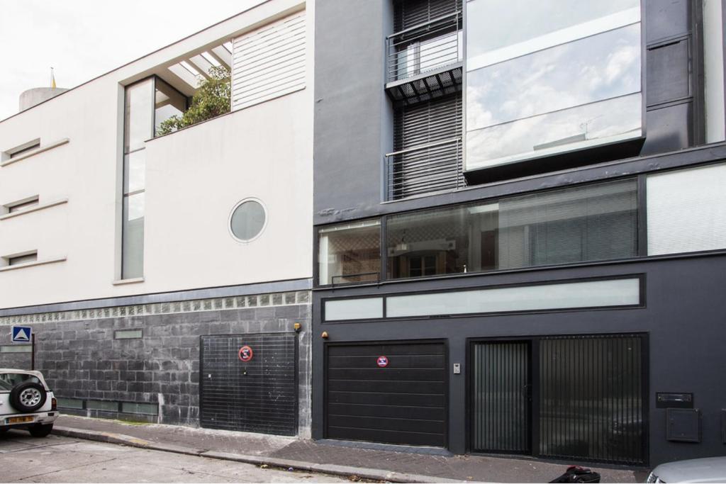 un bâtiment avec deux portes de garage dans une rue dans l'établissement maison d'architecte de 6 niveaux à Paris, à Paris