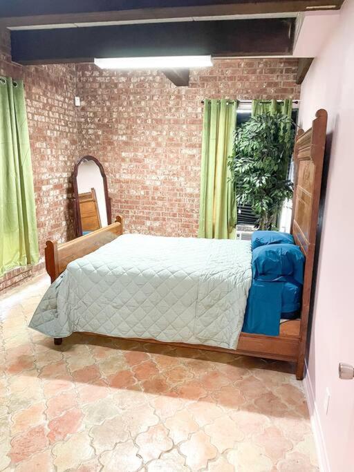 - une chambre avec un lit et un mur en briques dans l'établissement 5- Bed Pink house ( Close to Sports Center ), à West Monroe