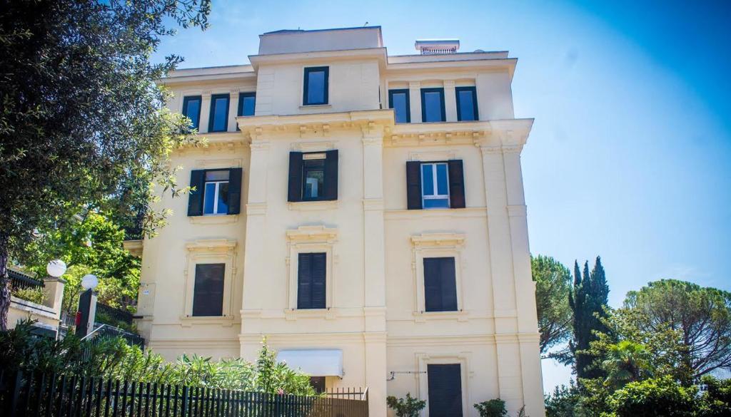 a tall white building with blue windows at Il Giardino in Tivoli