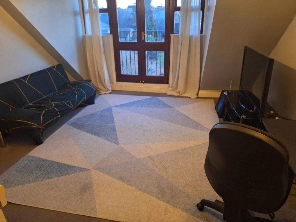 a living room with a couch and a chair and a television at Flat with excellent transport links to central London. in Elmers End