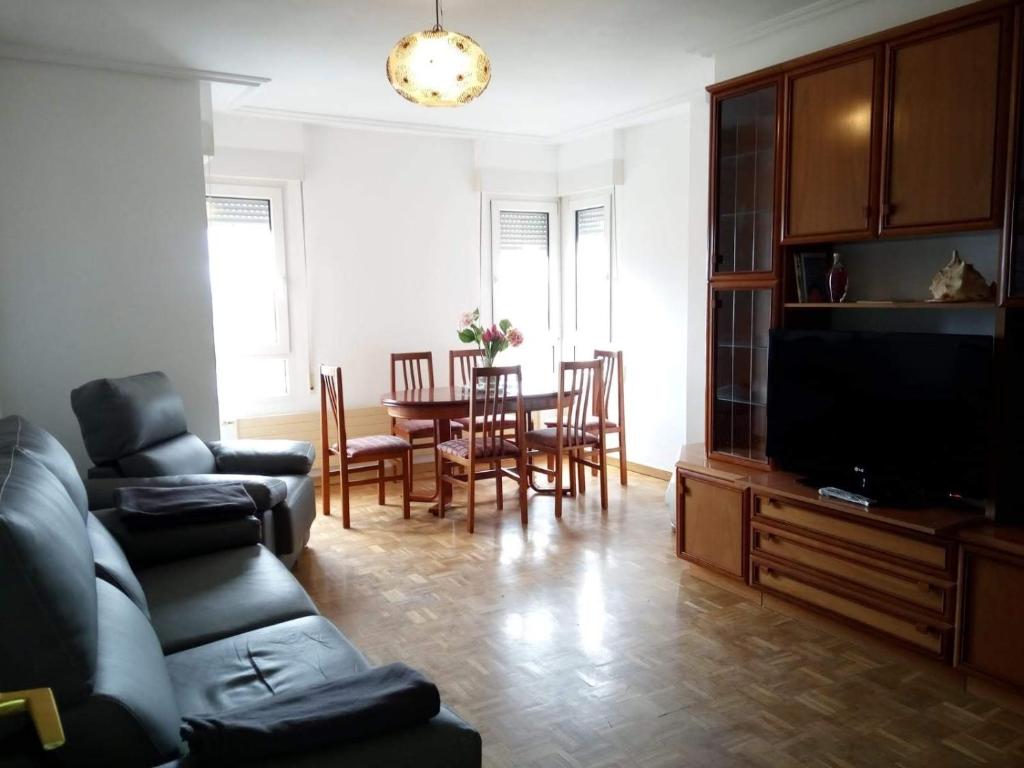 - un salon avec un canapé et une table avec des chaises dans l'établissement Apartamento centro Vitoria, à Vitoria-Gasteiz
