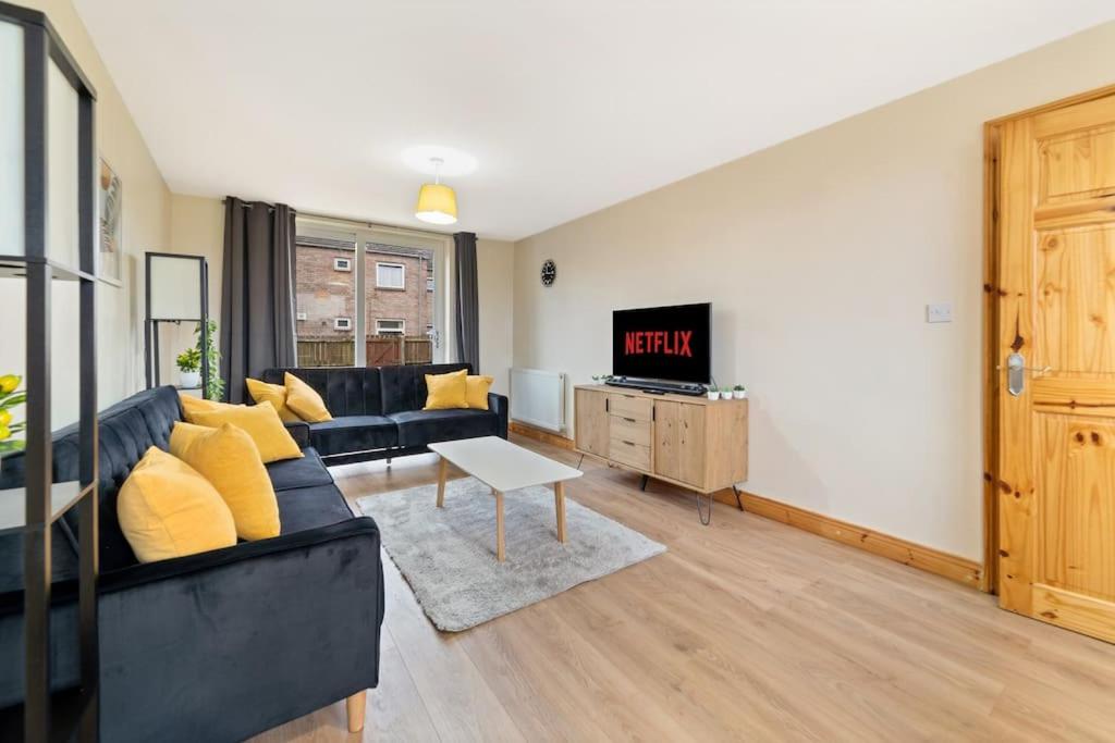 uma sala de estar com um sofá preto e uma televisão em Professionals,Contractors,Family em Leicester