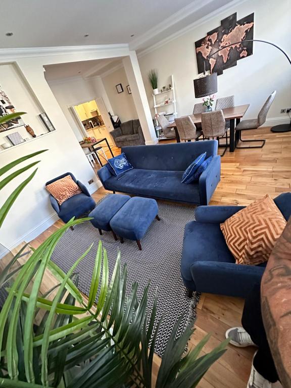 ein Wohnzimmer mit blauen Sofas und einem Tisch in der Unterkunft Bond MAYFAIR in London