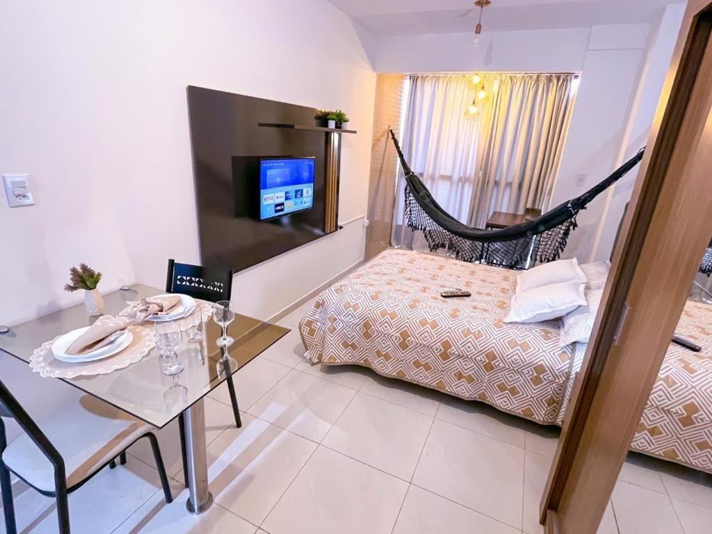 a bedroom with a hammock bed and a table and a television at Ap standard confort bem localizado in Campina Grande