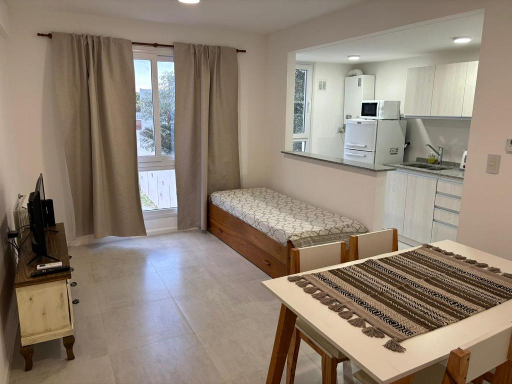 ein Wohnzimmer mit Couch und Tisch und eine Küche in der Unterkunft Departamento Céntrico Pampa Haus in Santa Rosa