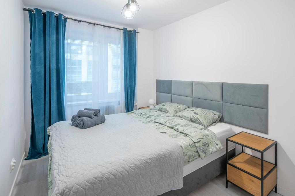 een slaapkamer met een groot bed en blauwe gordijnen bij Stylowy apartament Blue ~self check in 24h in Wrocław