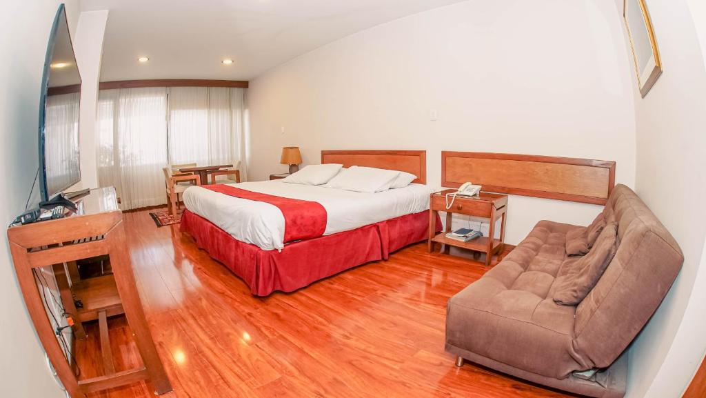 um quarto de hotel com uma cama e uma cadeira em Hotel Boyaca Plaza em Tunja