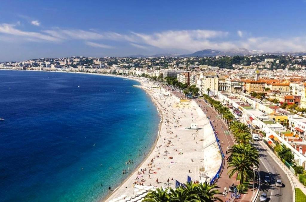 une vue d'une plage avec des gens et l'océan dans l'établissement Riviera Cocoon - Nice Center, à Nice