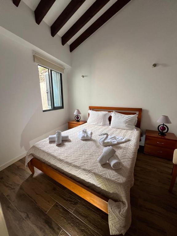 1 dormitorio con 1 cama con toallas en CASA DOS CEDROS en Pico da Pedra