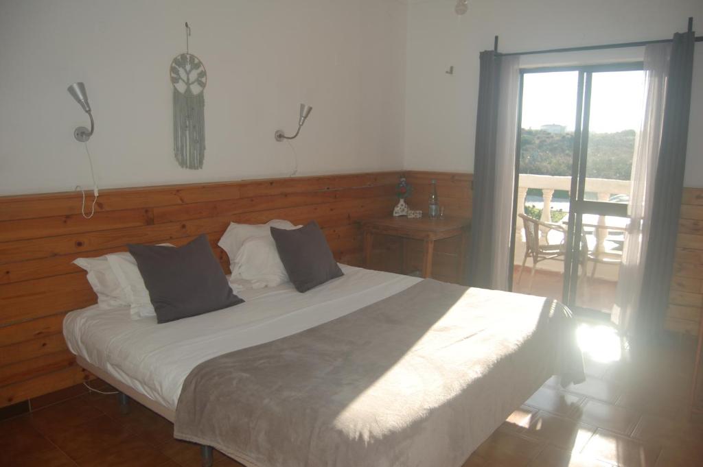 a bedroom with a bed and a sliding glass door at CASA DA HORTA in Aljezur