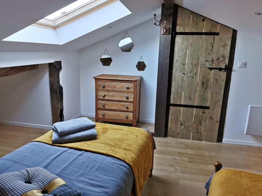 a bedroom with a bed and a sliding barn door at L’ESPRIT JANADE – GITE 4 A 6 PERSONNES. in Fénols