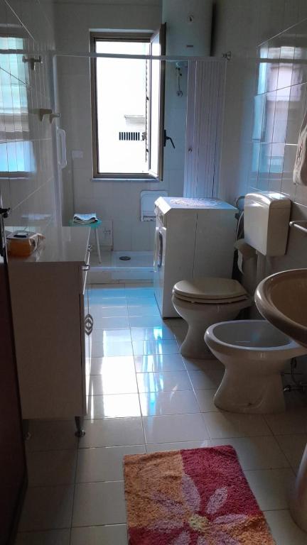 łazienka z 2 toaletami, umywalką i oknem w obiekcie Monti e mare. Vacanza relax 