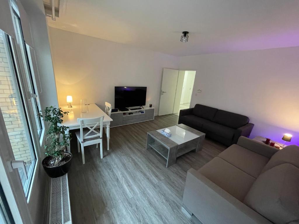 ein Wohnzimmer mit einem Sofa und einem Tisch in der Unterkunft Cozy apartment city nightlife in Düsseldorf