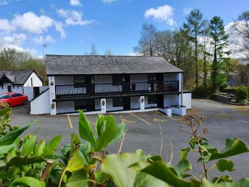 a large building with a balcony and a parking lot at Fairy Falls Hotel in Trefriw
