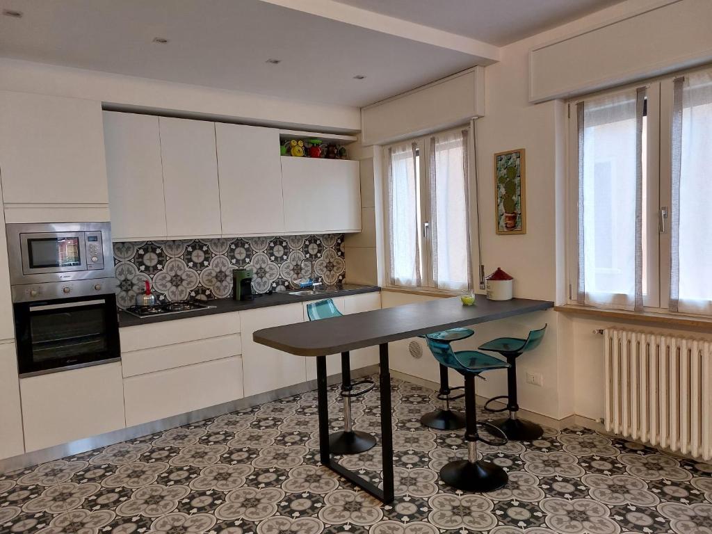 uma cozinha com armários brancos e uma mesa e cadeiras em Gulliver em Garda