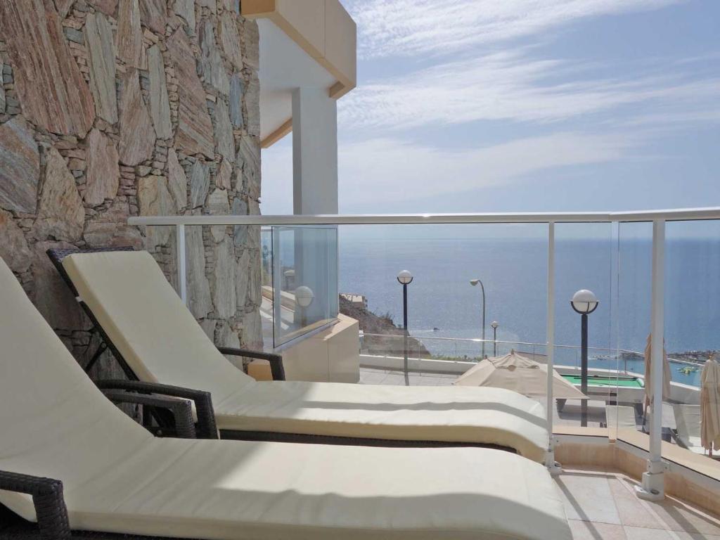 艾瑪道爾斯的住宿－阿馬多雷斯韋斯特公寓式酒店，阳台配有椅子,享有海景。