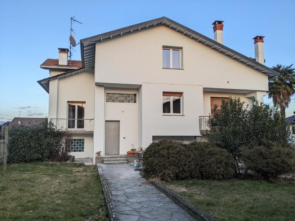 a large white house with a palm tree at Lago Maggiore - Loft Apartment in Ispra