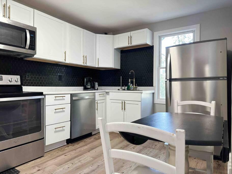 a kitchen with a table and a stainless steel refrigerator at Rotherwood Roost / 2BR/1BA Apartment near UE in Evansville