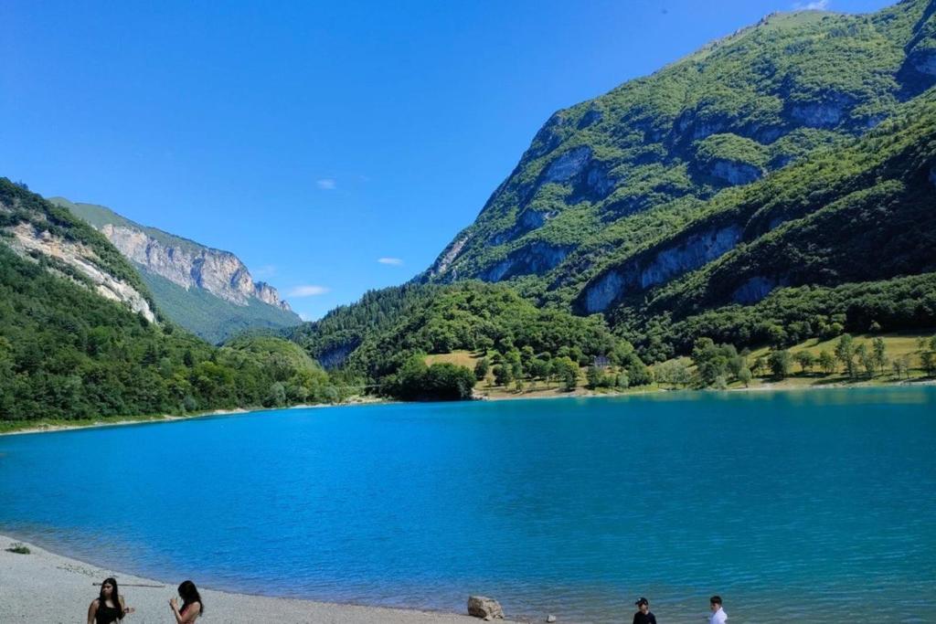 un grupo de personas de pie en una playa cerca de un lago en CASA DOLCE VITA, en Cares