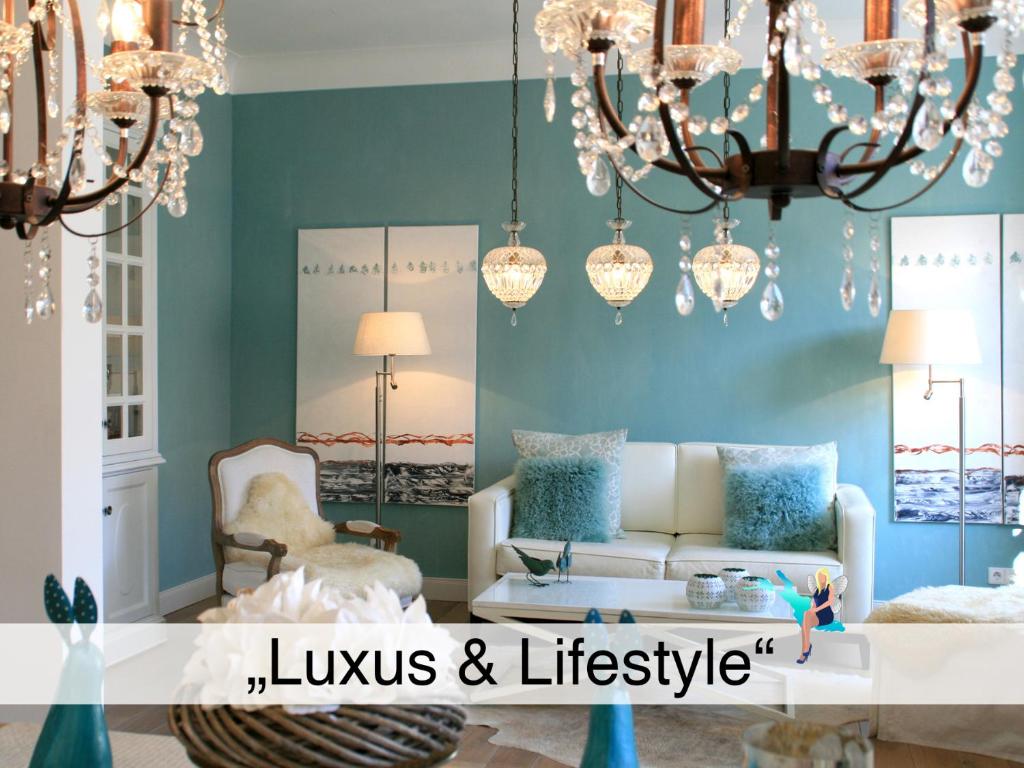 sala de estar con sofá y lámpara de araña en Ferienwohnung Luxus & Lifestyle, en Lindau