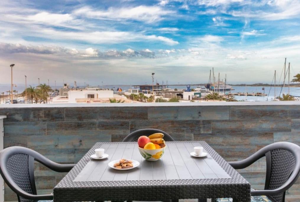 a table with a bowl of fruit on a balcony at Apartamentos El Puerto, La Savina in La Savina