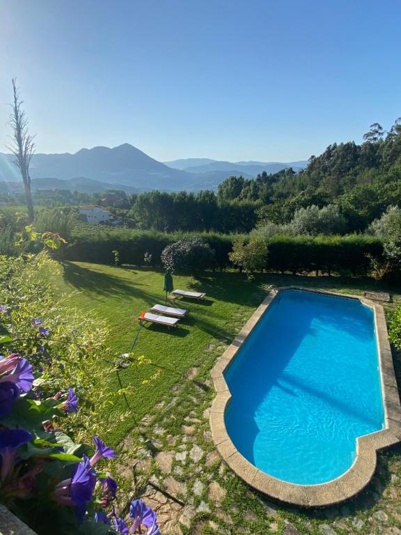 uma piscina num jardim com montanhas ao fundo em Turra Nature House em Celorico de Basto