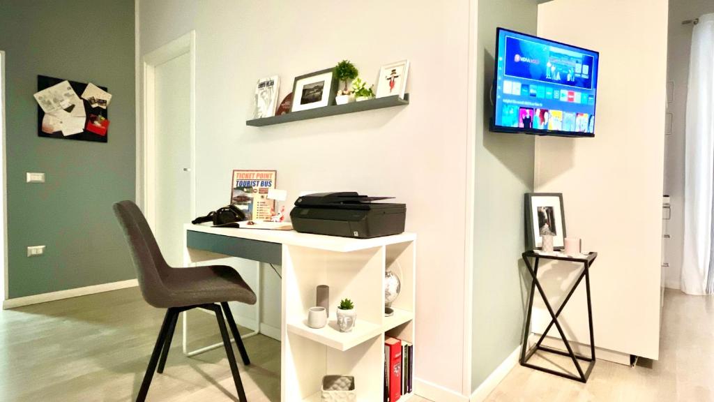 ナポリにあるArchivio 32 Neapolitan Apartmentのデスク、椅子、テレビが備わる客室です。