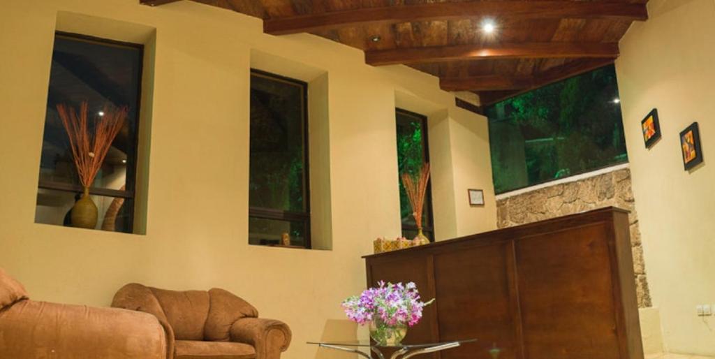 sala de estar con sofá y chimenea en Hotel y Bungalows Santa Ana, en Quetzaltenango