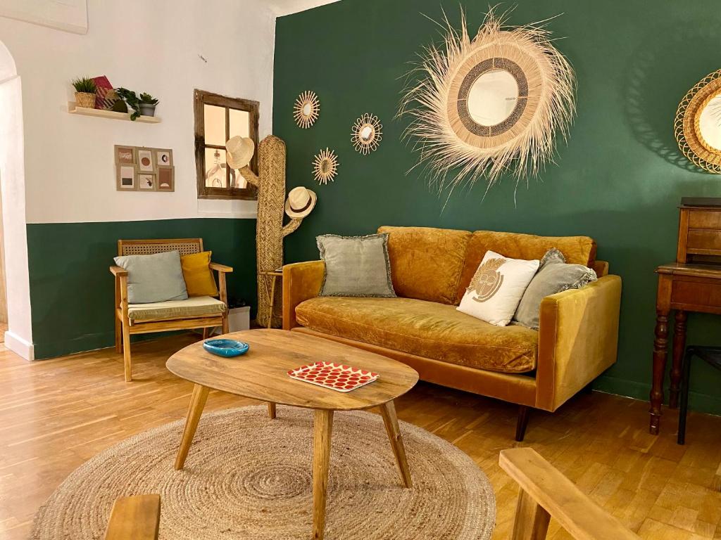 sala de estar con sofá y mesa en La Mansio, en LʼIsle-sur-la-Sorgue