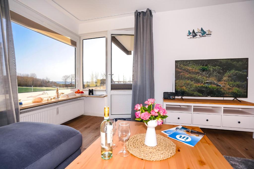 uma sala de estar com uma grande janela e uma televisão em Hanseat I Whg 34 em Grömitz