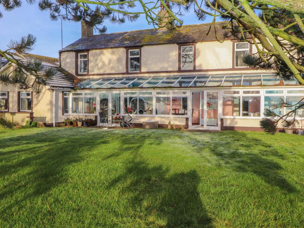 a large house with a lawn in front of it at The Stables in Wigton