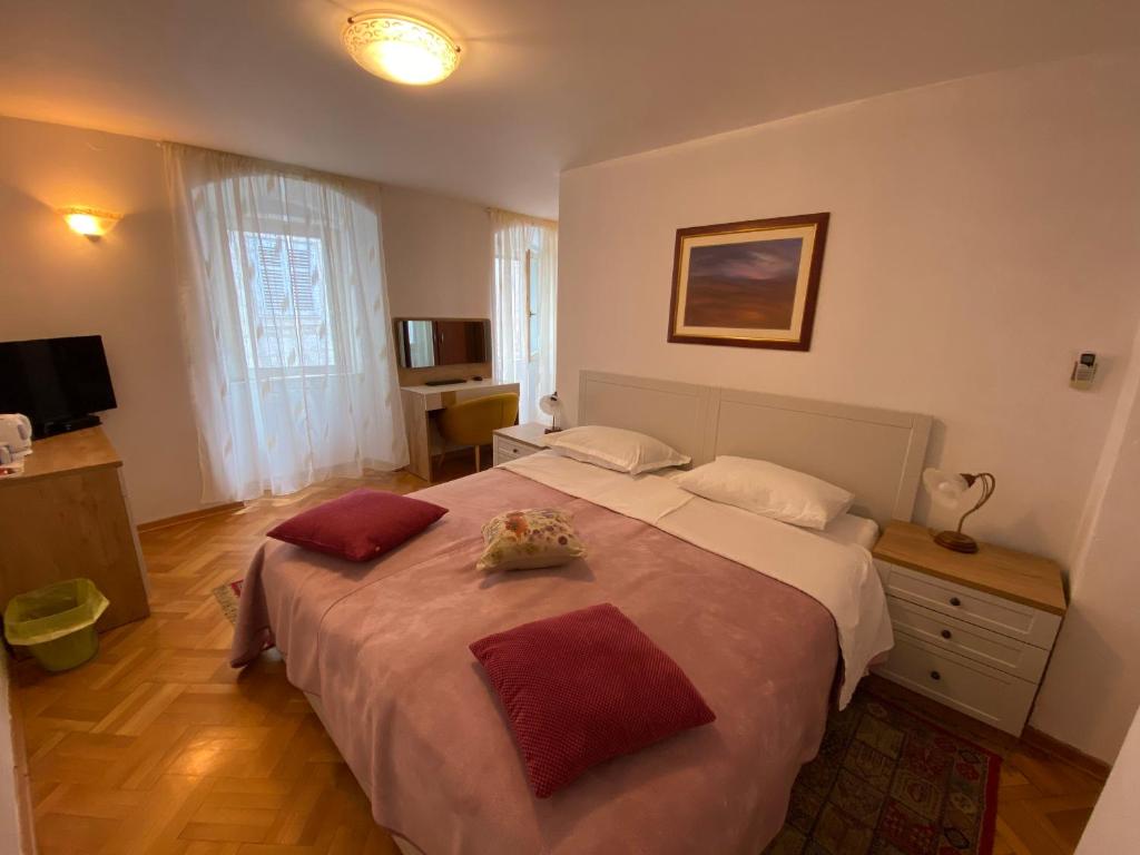 a bedroom with a large bed with two pillows on it at Rooms Base in Split