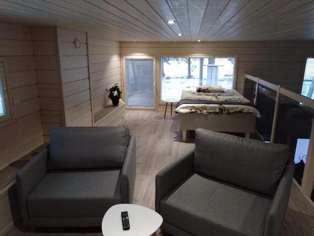 a small room with two chairs and a bed at Koivuniemen Tila 3 in Säkylä