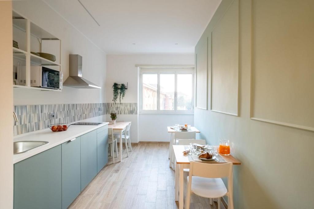a kitchen with blue cabinets and a table and chairs at La dolce vita rooms in Rome