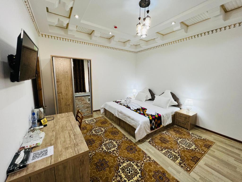 een slaapkamer met een bed en een televisie. bij Lola Boutique Hotel in Bukhara